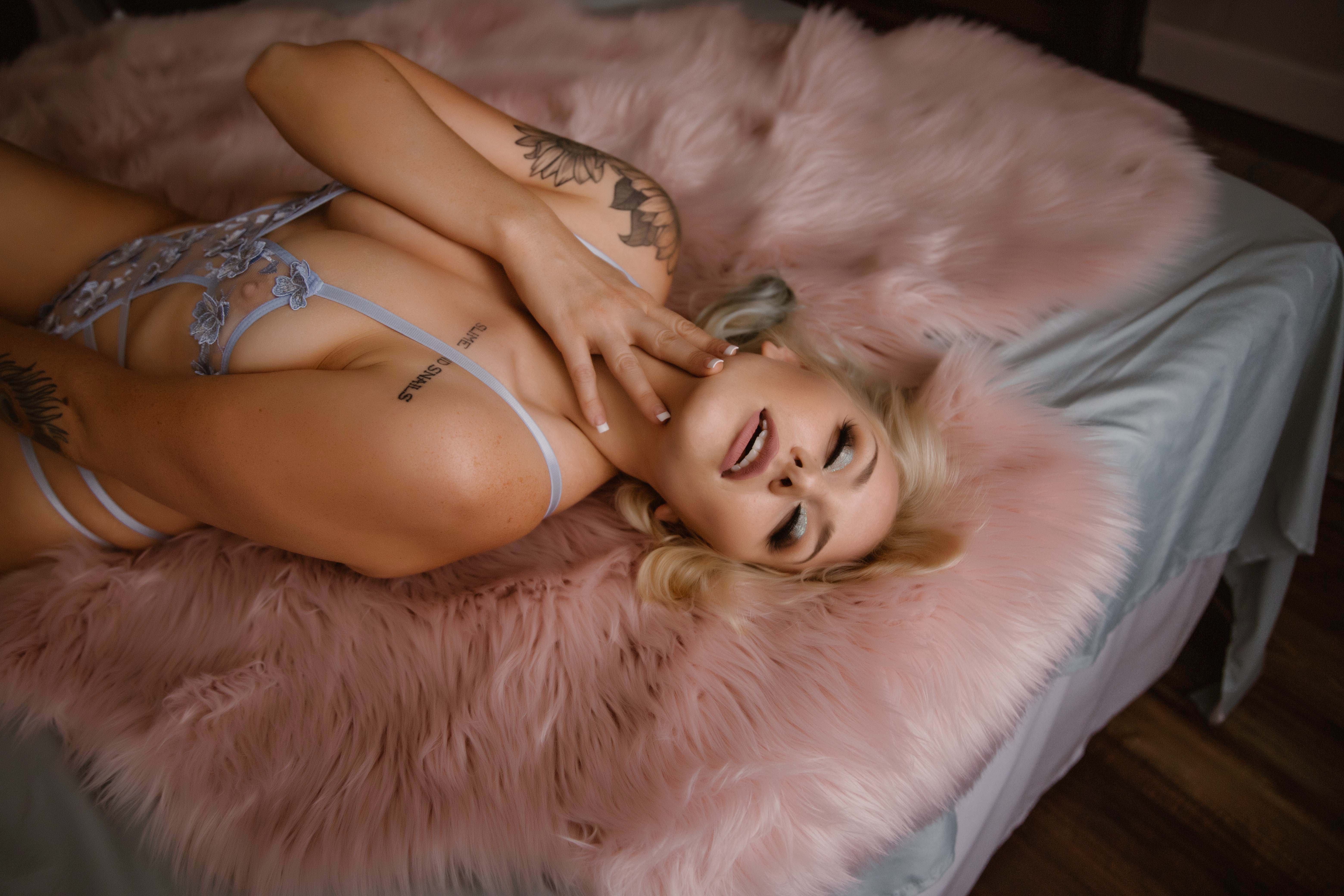 Image of a woman lying on a pink rug in lingerie