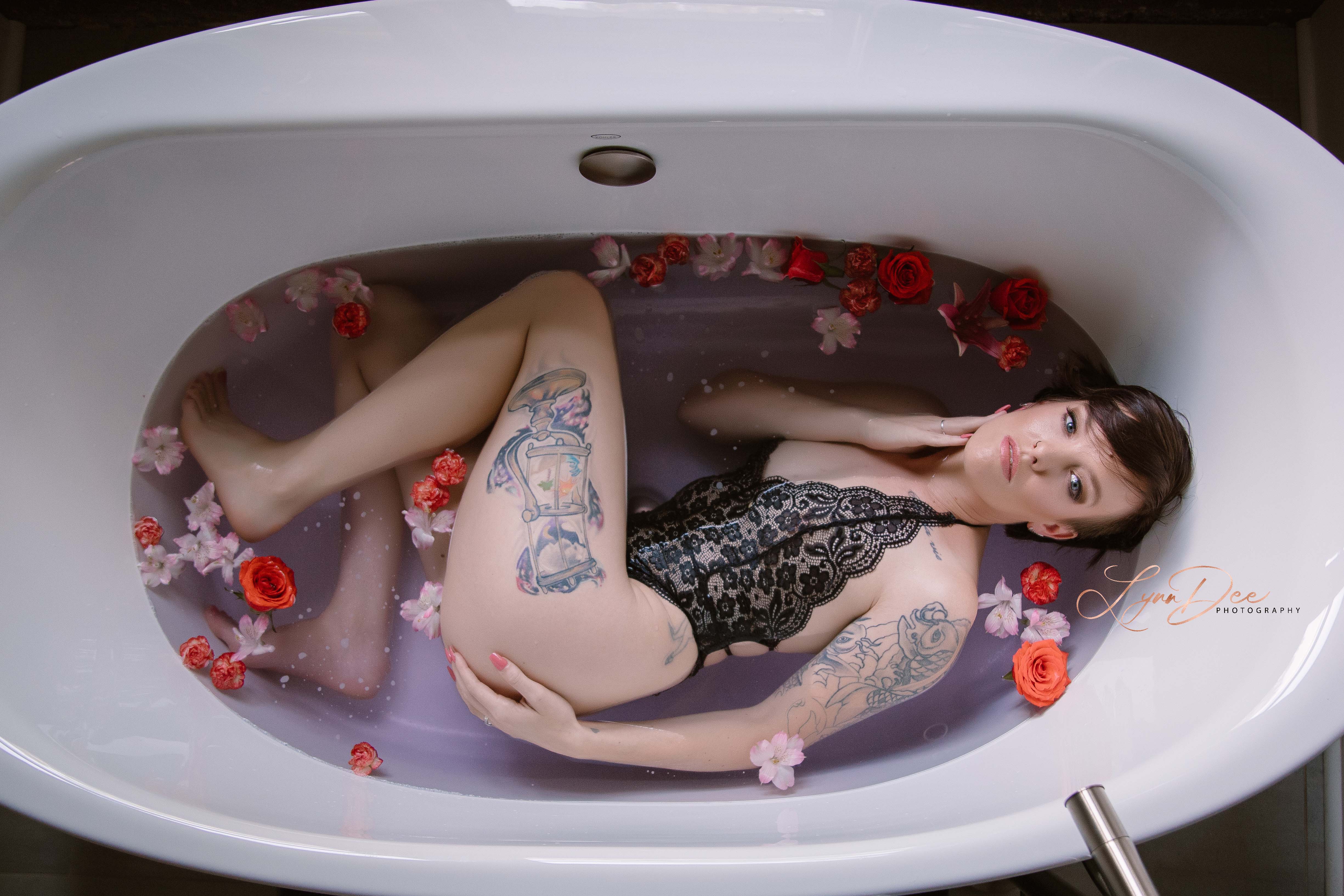 woman lying on her side in a bathtub filled with flowers