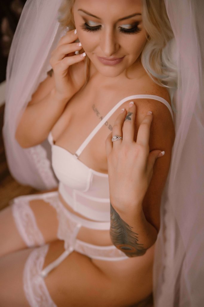 portrait shot of a bride gazing at her engagement ring during a bridal boudoir shoot